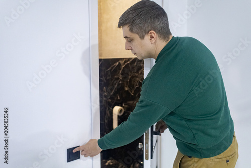 Canvas Print A man walks into the restroom at night due to frequent urination or digestive issues
