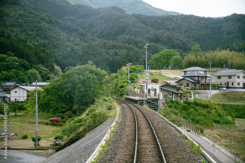 Rural railway station with curved track seen from leaving train