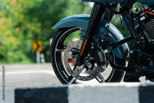 Close up of motorcycle front wheel with disc brake on sunny day