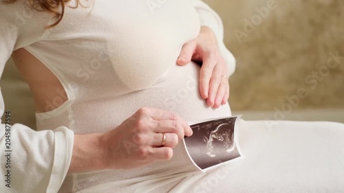 a pregnant woman's belly with an ultrasound image, a woman expecting a baby, a close-up of the belly, and an ultrasound image of a baby