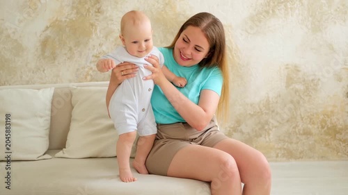mother and baby, mother gently kissing the baby, playing with its legs, mother's love and care