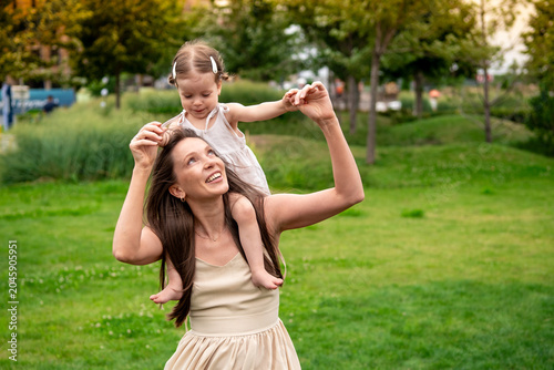 Bild auf Leinwand a mother and a child playing and having fun in a park, a mother and a baby walki