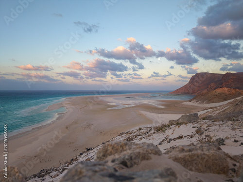 Sandy beach and cliffs under soft evening sky