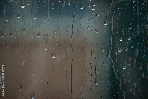 Obraz na płótnie Rain drops on a window during a rain storm giving a moody athmosphere