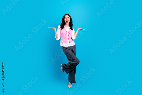 Foto Joyful businesswoman in pink vest posing confidently on blue background, celebra