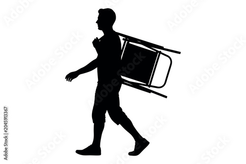 Bilde på lerret Silhouette of a man carrying a folding chair walking in a casual stride