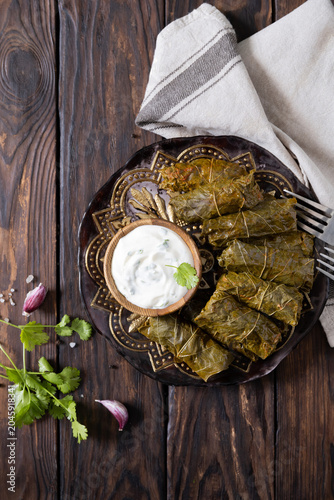 Delicious dolma (sarma), dolmades stuffed grape leaves rice, white yogurt sauce. Mediterranean Dolma. Lebanon turkish greek middle eastern cuisine. View from above. Copy space.