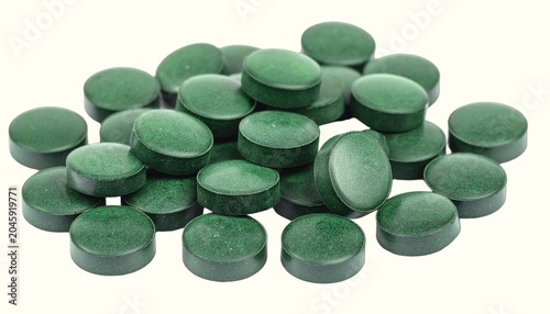 Small Pile of Green Organic Spirulina Algae Nutritional Supplement Tablets Isolated on White Background