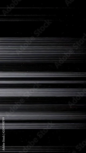 Glitchy analog video noise with tearing scan lines. Distorted broadcast signal for retro horror background. Dark screen effect with static interference artifact. Vertical video