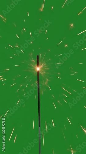 Sparkler igniting with vibrant golden sparks on green screen chroma key background, radiating outwards in a dynamic explosion, symbolizing celebration, joy