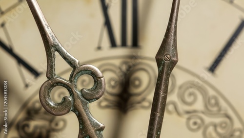 Close up of antique clock face showing hands and roman numerals