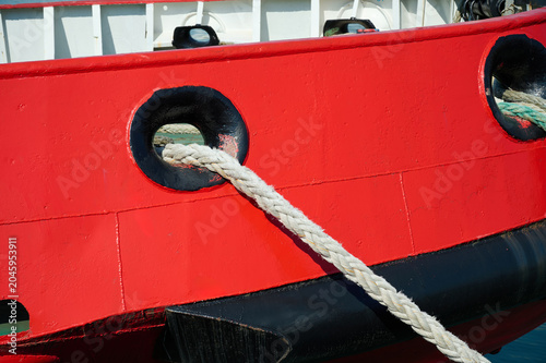Fotografie A ship moored in port with large sea ropes.