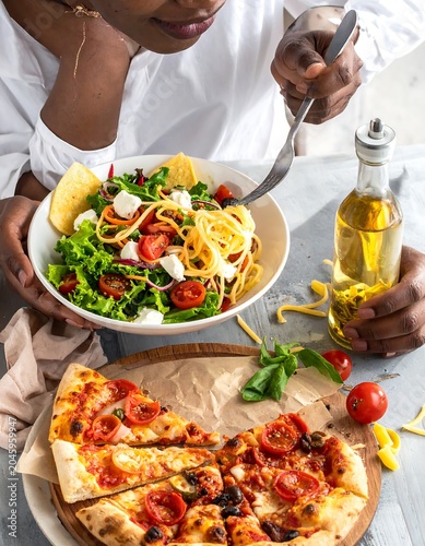 Woman enjoying a vibrant salad and tomato-topped pizza, set on a wooden board, bathed in bright, airy light