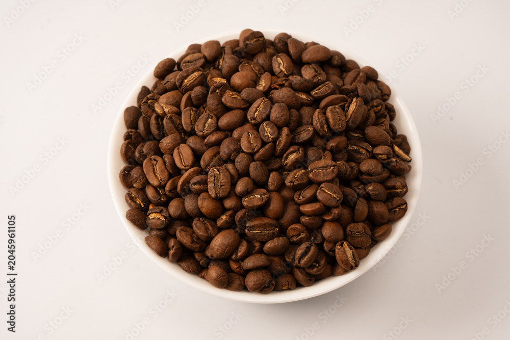 Fototapeta premium Coffee beans on a white background. Top view. Coffee beans texture.