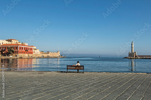 Tourist on Bench Viewing Chania Harbor