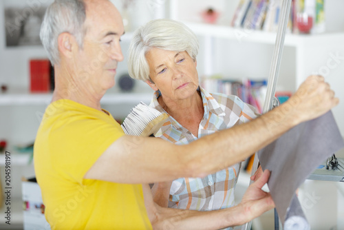 Photos senior couple considering wallpaper to redecorate with