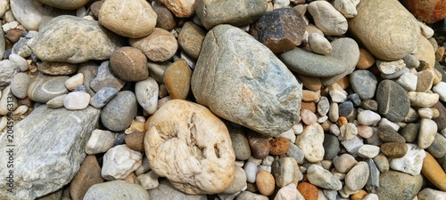 Cuadro en lienzo Earthy tones of natural river pebbles representing raw untouched wilderness, exc