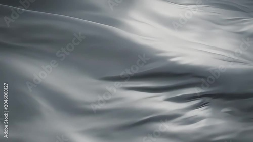 Fabric waves create a soft gray texture that flows across the dark frame.