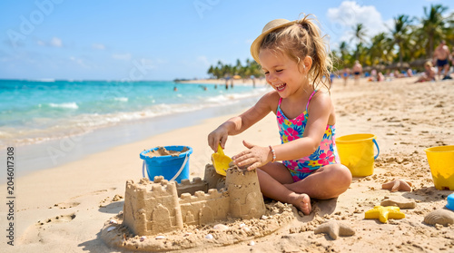 Adorable little girl full of pure joy playing and creating a detailed sandcastle on a pristine beach, enjoying a vibrant summer vacation by the tranquil sea