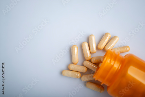 Health care background of pills and bottle on white surface flat lay