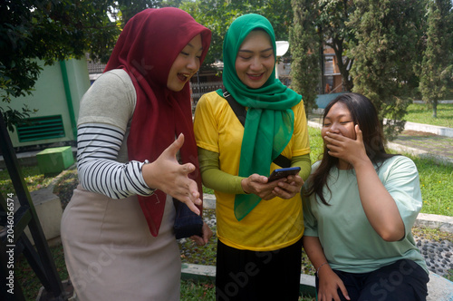 Three Asian Young Girls Enjoying Watching Sports Game On Mobile Phone Live Streaming