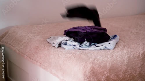 Close Up of Assorted Clothing Falling onto Bed Creating Large Pile, Concept of Clothing Donation, Textile Recycling and Sustainable Fashion