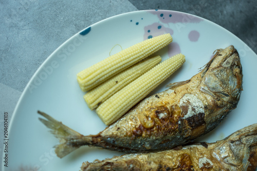 Fried mackerel fish served with boiled baby corn. Thai homemade