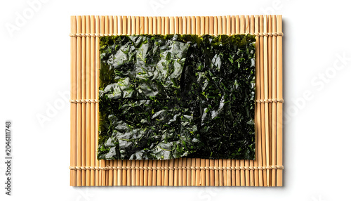 Dried seaweed sheet on bamboo mat, textured green nori for sushi and Asian cuisine, isolated food ingredient