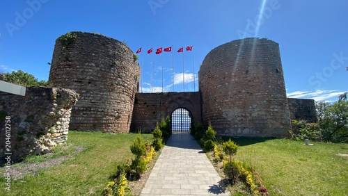 Front entrance of the historic Eskihisar Castle in Gebze, Kocaeli, Türkiye, featuring its ancient stone towers under a clear blue sky.
