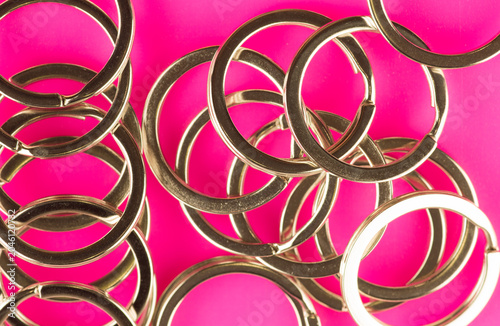 multitude of key rings laid out on a pink background