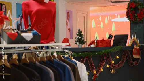Tableau sur toile Rack of formal attire shirts in empty Christmas decorated clothing store waiting for customers looking for presents during winter holiday season