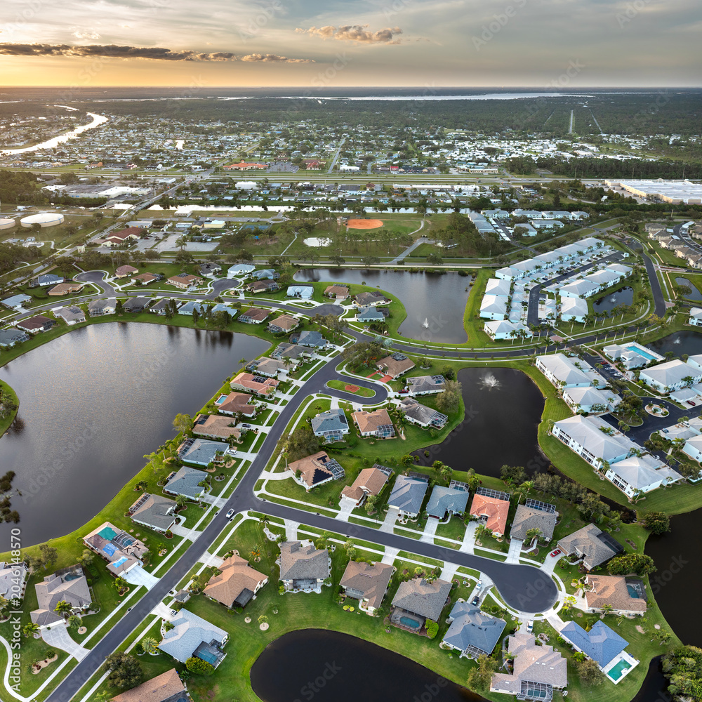 Obraz premium Aerial view of expensive residential houses in small town in southwest Florida. American dream homes as example of real estate development in US suburbs