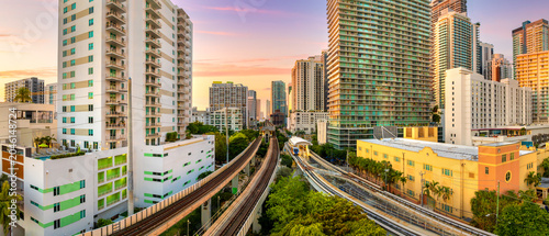 Urban railroad cuts through Miami downtown Brickell district. Public train connecting city between towering American skyscrapers