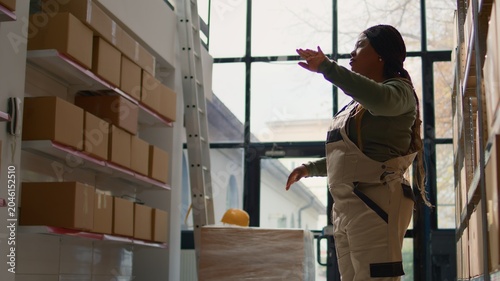 Quadro em tela Manager in warehouse using AR holographic technology to visualize how to best stash parcels on shelves to make room for more