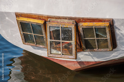 Close-up of a cabin window at the stern of an old sailing ship in a harbor on the Baltic Sea