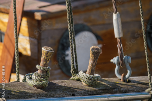 Close-up of ropes secured to a belaying pin on an old sailing ship in a harbor on the Baltic Sea