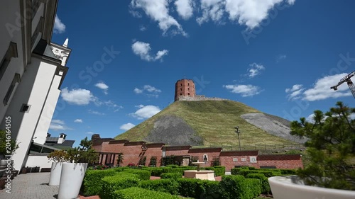 Gediminas Tower stands majestically atop Gediminas Hill under a bright blue sky with white clouds, offering a picturesque view of this historic landmark in Vilnius, Lithuania.