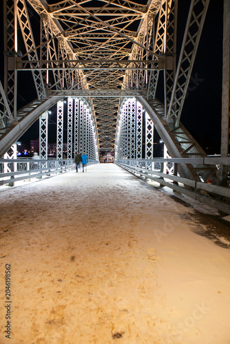 The first arch bridge built in Russia—the Belelyubsky Bridge—features architectural and artistic nighttime illumination. Borovichi, Novgorod Oblast, Russia.
