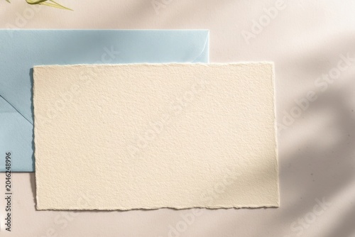 Blank card and envelope on a light surface with soft shadows