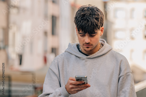 Φωτογραφία portrait of a young man with a mobile phone on the street