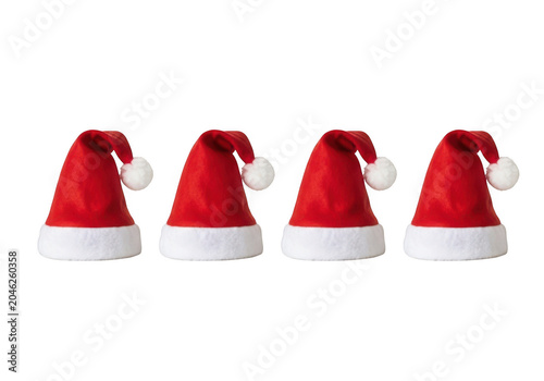 Four red Santa hats lined up on a clean surface