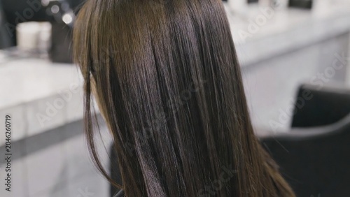 Close-up of healthy, dark brown hair with subtle highlights, showcasing a smooth texture and natural shine, ideal for beauty and haircare advertising.