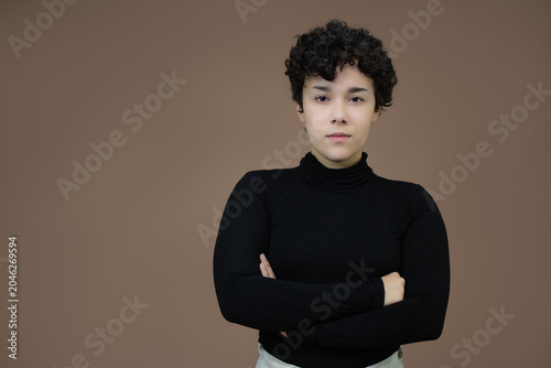 Quadro su tela Serious young woman with short hair, standing with arms crossed