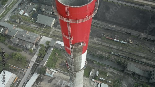 Industrial alpinism,industrial climbing Painters Coating Tall Chimney Stack at Industrial Facility Maintenance and Restoration Work at Height.Professional industrial painters performing maintenance