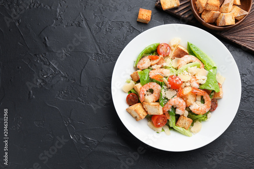 Canvastavla Delicious Caesar salad with shrimps and croutons on grey textured table, flat lay