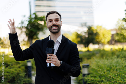 Photos Professional male journalist holding microphone presenting breaking news