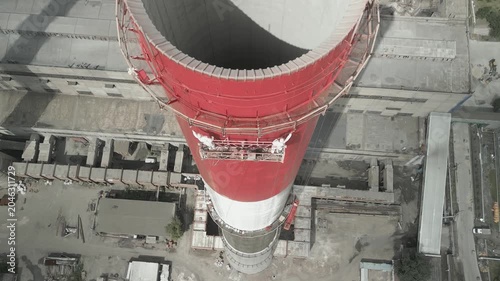 Industrial Painters Coating Tall Chimney Stack at Industrial Facility.Work at Height.Concept of industrial maintenance,occupational,infrastructure renovation,engineering services,construction industry