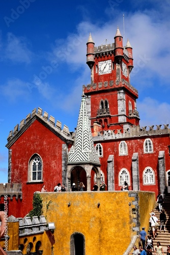 Fotografie Close-up of the vibrant red clock tower and detailed Manueline architecture of the Pena National Palace (Palácio Nacional da Pena) in Sintra, Portugal