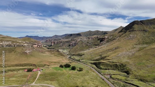 Aerial View South Africa Mountain Valley Showcasing Redroof Farmhouse Beside Winding Road, Green Grassland