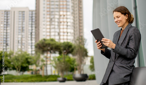 Woman using tablet while si...